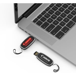A black and red LED flash drive is connected to a laptop, with a logo visible on the drive.