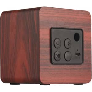 A square speaker with a wood-like finish, featuring control buttons and a USB port. It has a minimalist design.