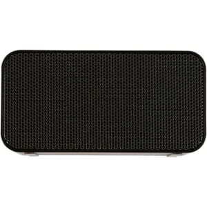 A rectangular black wireless charging speaker with a textured mesh grille on the front and a smooth finish.