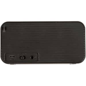 A black wireless charging speaker with ports and buttons on the back, featuring a subtle textured design.
