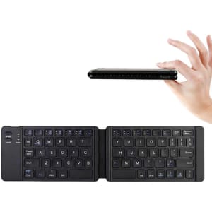 A foldable Bluetooth keyboard in black, being held in a hand, featuring a compact design with illuminated keys.