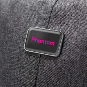A grey backpack with a logo on the side, featuring the word "Phantom" in pink.