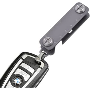 A grey Keyper Case with a keyring attachment, featuring a measuring scale and a sleek design for holding keys.