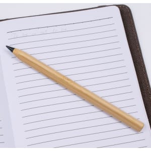 A bamboo pen resting on a lined notebook page, featuring a simple and natural design.