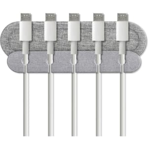 A grey cable organiser with several white charging cables neatly arranged on it. It features a branding logo.