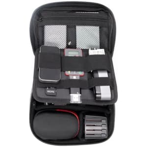 A black toiletry bag featuring compartments for electronic devices, chargers, and accessories, with a sturdy zipper.