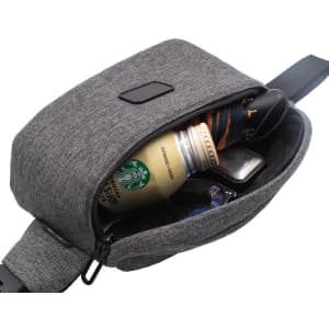 A grey anti-theft sling bag with a drink bottle, sunglasses, and a wallet visible inside.