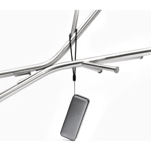 A compact black Bluetooth speaker hanging from a metal frame, featuring a sleek design and a strap.