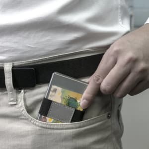 A silver RFID wallet is partially placed in a pocket, featuring a dark strap.