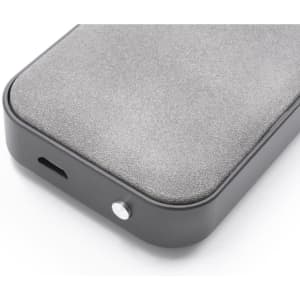 A grey wireless speaker with a smooth surface, featuring a port and a button. It has a minimalist design with a logo.