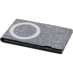 A grey wireless charger with a simple circular logo design, featuring a textured fabric finish.