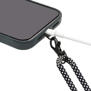 A phone with a black and white lanyard wristband eco strap connected to its charging port.