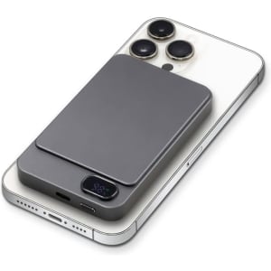 A grey magnetic wireless power bank sits on a smartphone, featuring a sleek design and a logo.