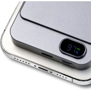 A grey power bank with a digital display showing battery percentage, designed for wireless charging.