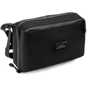 A black toiletry bag featuring a logo, with multiple compartments and a carry strap.