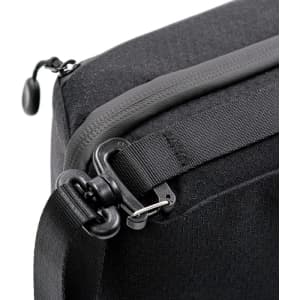 A black toiletry bag featuring a zipper closure and a detachable shoulder strap with a clip.