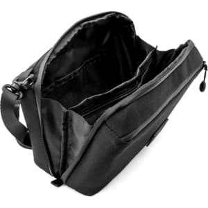 A black toiletry bag with multiple compartments and an adjustable strap. It has a logo on the exterior.