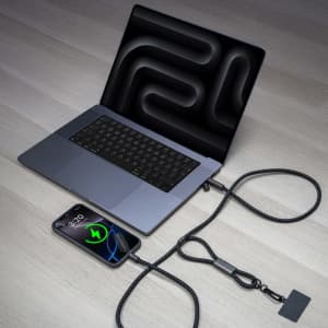 A black braided lanyard phone strap connected to a laptop and a smartphone, showcasing charging capability.