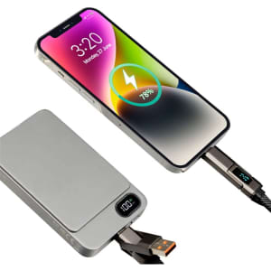 A silver power bank connected to a phone displaying a charging icon and battery percentage. The cable is black with a logo.