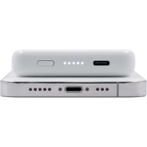 A white magnetic wireless power bank with LED indicator lights and USB-C ports on a silver surface.