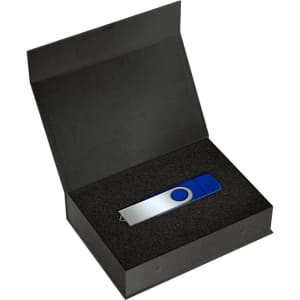 A blue and silver USB drive sits inside a black magnetic gift box lined with foam. The box is open.