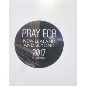 A round, 70mm fridge magnet in black and white featuring a logo, dates, and a textured background.