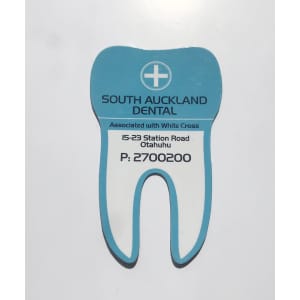A tooth-shaped magnet in light blue and white, featuring a dental clinic's logo and contact information.