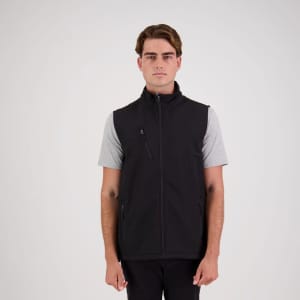 A man wearing a black softshell vest over a grey t-shirt, featuring a zippered front and side pockets.