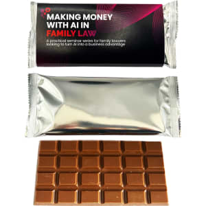 A chocolate bar in a silver wrapper, featuring a dark brown square chocolate pattern. The wrapper has distinctive branding.