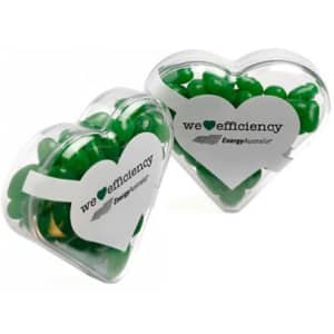 Acrylic heart container filled with green jelly beans, featuring a logo on the front.