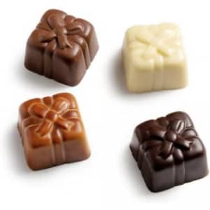 A selection of four chocolate squares in dark, milk, and white chocolate, each shaped like a gift with ribbon detailing.
