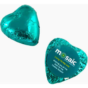 A teal chocolate heart wrapped in foil, featuring a circular branding label on one side.
