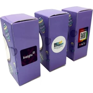 Three purple chocolate boxes featuring a window, with branding on the sides. Each box is decorated with Easter-themed graphics.
