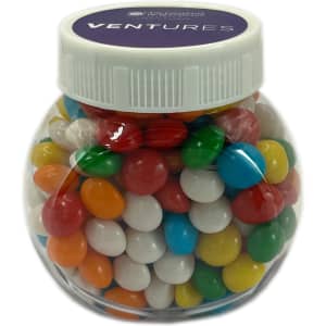 A clear plastic jar filled with colourful chewy fruit candies, including red, blue, green, yellow, and white.