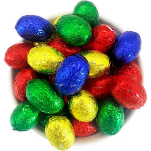 A bowl filled with small, colourful chocolate eggs wrapped in shiny foil—red, green, blue, and gold.