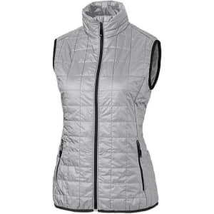 A light grey ladies' puffer vest with a high collar and zippered pockets, featuring a logo on the front.