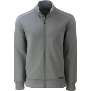 A full zip jacket in a muted green colour, featuring a high collar and a logo on the hem.