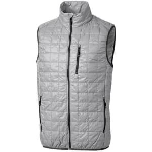 A grey quilted men's vest featuring a high collar and zippered pockets. It has a logo on one side.