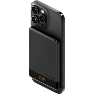 A black magnetic wireless power bank attached to a smartphone, featuring a sleek design and slim profile.