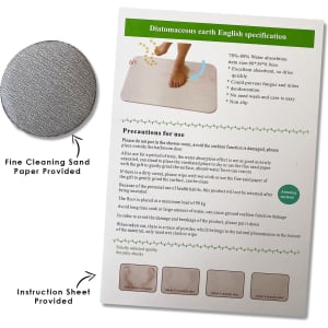 A grey bath mat made of diatomaceous earth with an instruction sheet and fine cleaning sandpaper included.