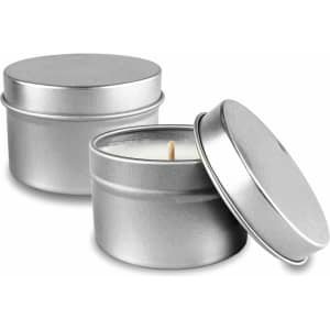 Two silver tin candles with lids, one slightly open to reveal a white candle inside.