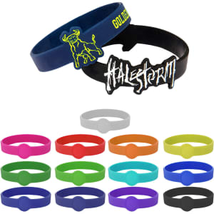 A selection of silicone wristbands in various colours, featuring a logo and custom designs.