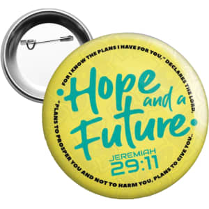 A round 75mm button badge in yellow, featuring a logo and text in teal.