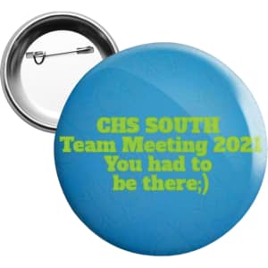 A 25mm round button badge in blue with a metal back and pin, featuring vibrant green text.