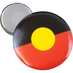 A round fridge magnet button badge featuring Aboriginal colours: black, red, and yellow with a shiny finish.