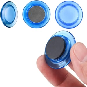 A blue plastic button magnet is held between fingers, showcasing its smooth surface and magnetic backing.