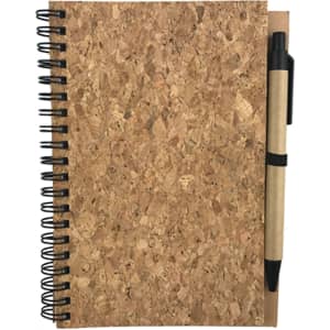 A cork notebook with a black spiral binding and a brown pen attached.