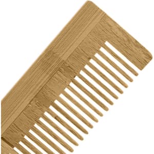A bamboo comb in a light brown shade with wide and narrow teeth, featuring a textured handle.