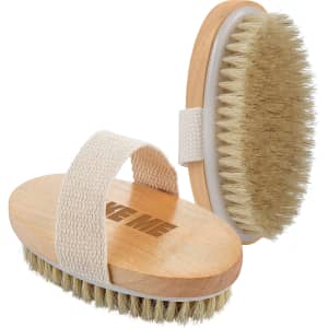 A wooden body brush with a soft bristle head and a fabric strap in a natural colour. It features a logo.
