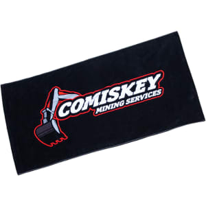 A black beach towel featuring a prominent logo for Comiskey Mining Services.